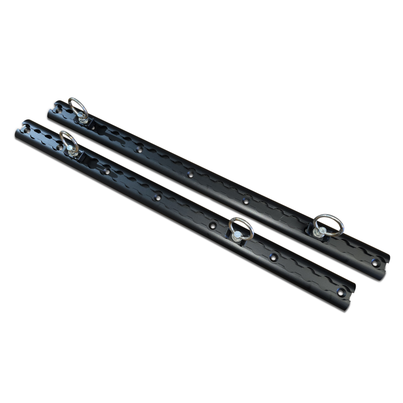 Two black metal tracks with holes and metal ring attachments on a plain black background.